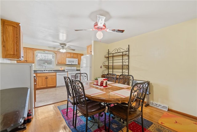 dining space featuring ceiling fan, sink, and light hardwood / wood-style flooring