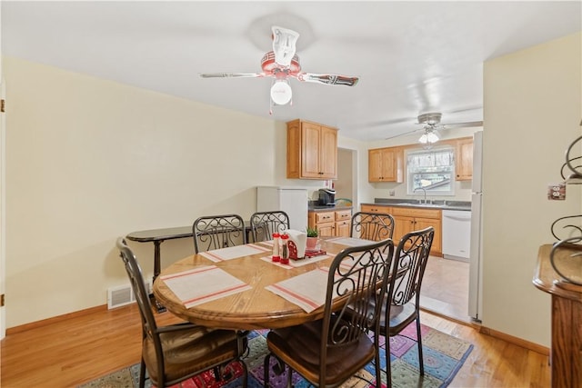 dining area featuring light hardwood / wood-style flooring, ceiling fan, and sink