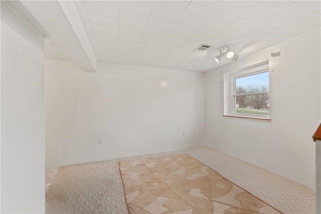 unfurnished room with beamed ceiling