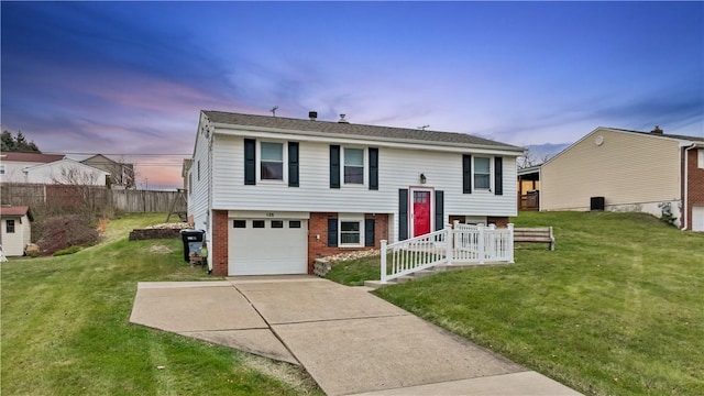 split foyer home with a lawn and a garage