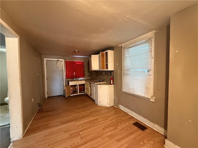 kitchen featuring white gas stove and light hardwood / wood-style floors