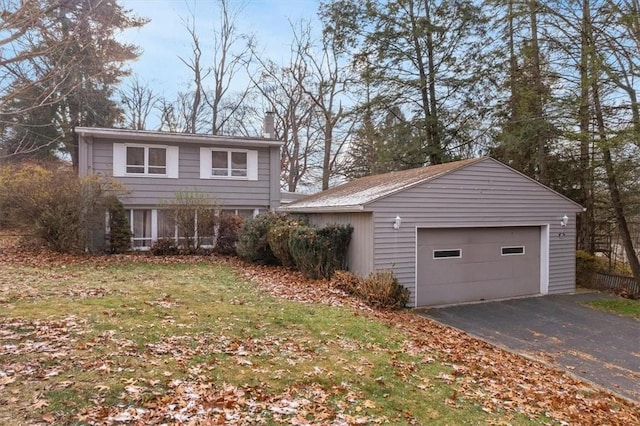 view of front of property featuring a garage, an outbuilding, and a front lawn