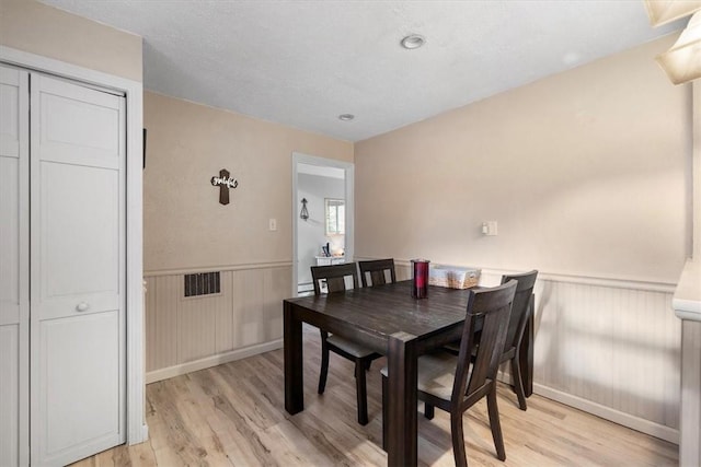 dining room featuring light hardwood / wood-style floors and a textured ceiling