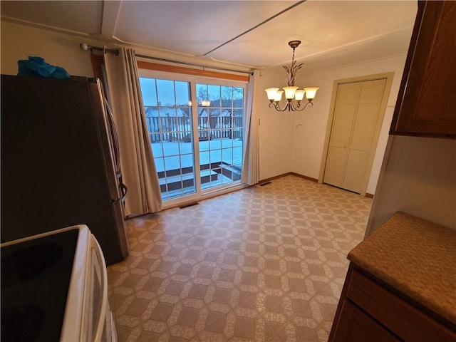 unfurnished dining area featuring a chandelier