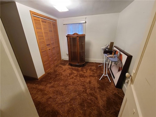 hall featuring dark colored carpet