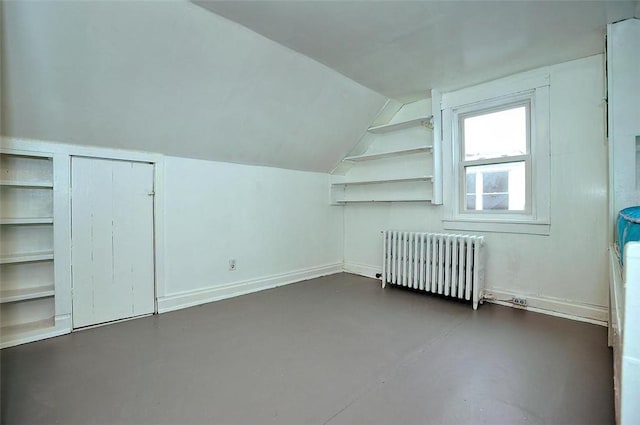 bonus room with radiator heating unit and vaulted ceiling