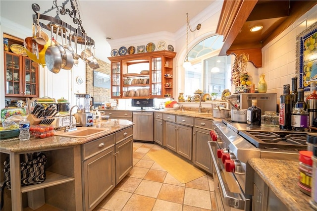 kitchen with light stone counters, ornamental molding, sink, and appliances with stainless steel finishes