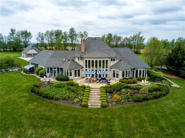 rear view of house with a patio area and a yard