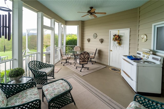 sunroom / solarium featuring washer / clothes dryer and ceiling fan