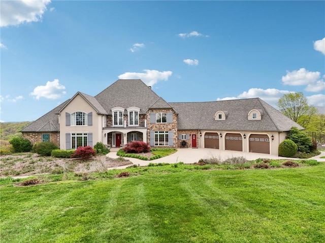 rear view of house with stone siding, a garage, stucco siding, concrete driveway, and a lawn