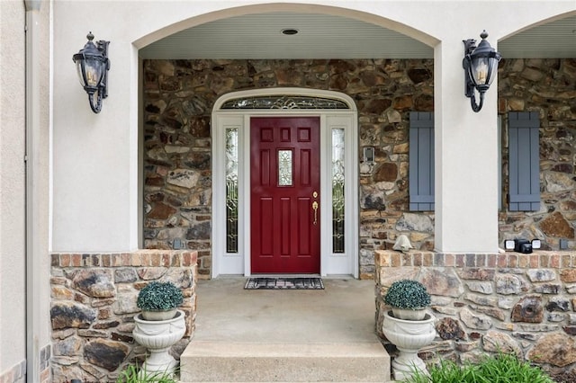 doorway to property with stucco siding and stone siding