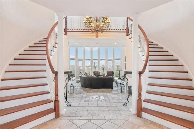 staircase featuring a towering ceiling, tile patterned floors, and a notable chandelier