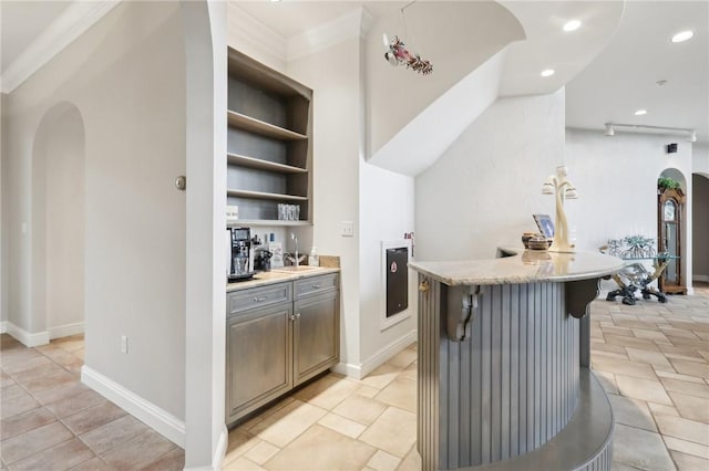 kitchen with arched walkways, open shelves, light countertops, a breakfast bar, and recessed lighting