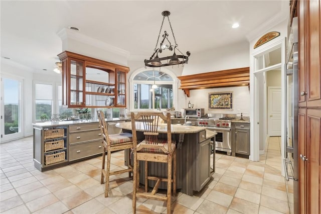 kitchen with light tile patterned floors, stainless steel range, a wealth of natural light, and glass insert cabinets