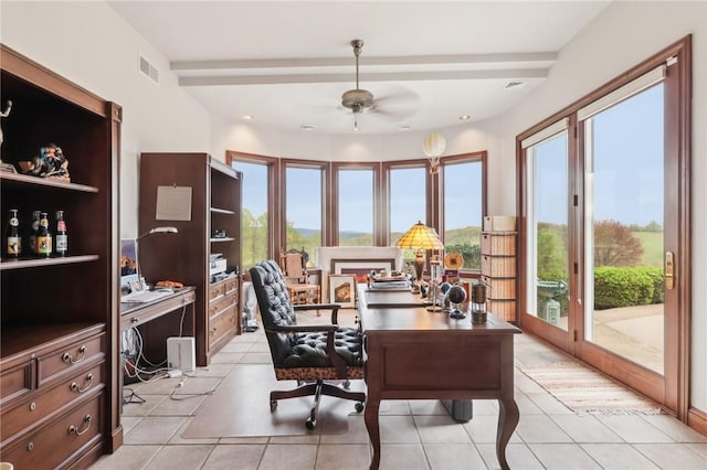 office area featuring visible vents, a ceiling fan, light tile patterned floors, and a wealth of natural light