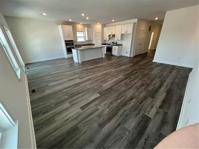 kitchen featuring white cabinetry, a kitchen island, dark hardwood / wood-style floors, and appliances with stainless steel finishes