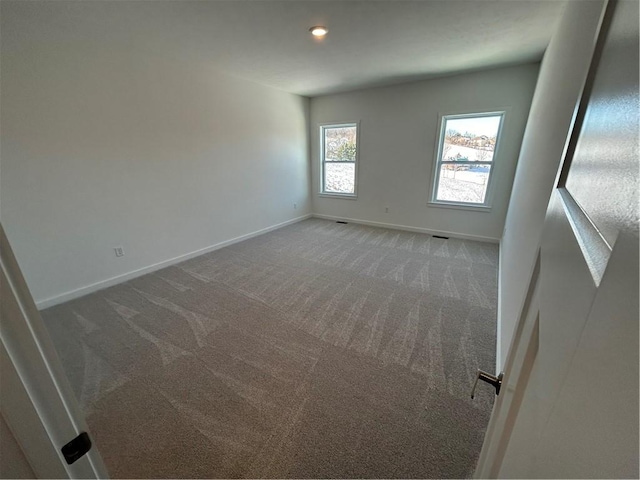 spare room with dark carpet