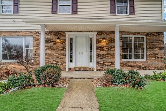 view of exterior entry with a yard