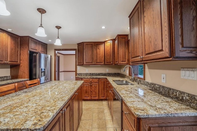 kitchen with appliances with stainless steel finishes, light stone counters, light tile patterned floors, pendant lighting, and a center island