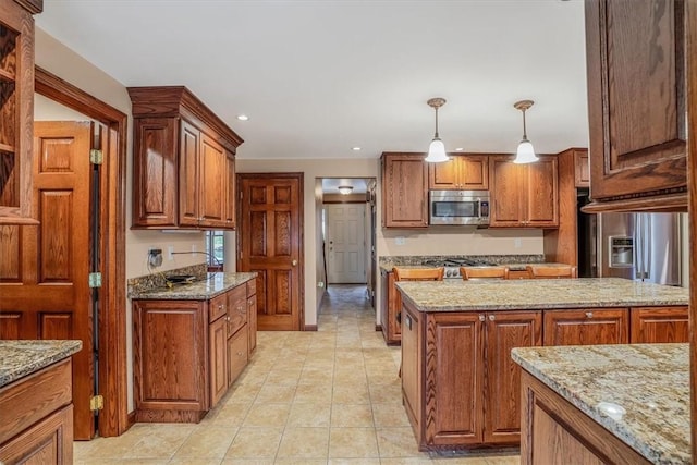 kitchen featuring decorative light fixtures, light stone countertops, and light tile patterned floors