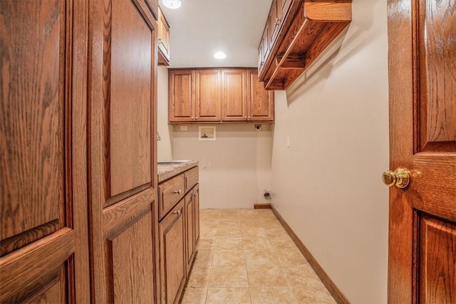 clothes washing area featuring sink, cabinets, washer hookup, electric dryer hookup, and light tile patterned floors