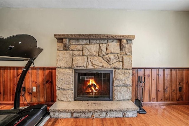 room details with a fireplace, wood-type flooring, and wood walls