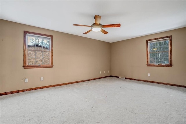 carpeted spare room with ceiling fan