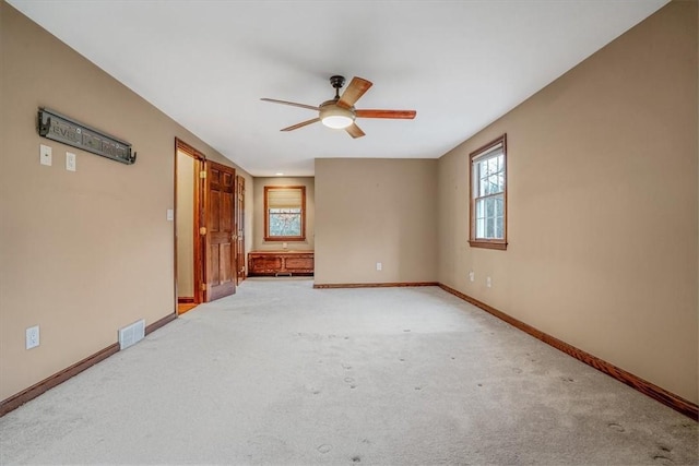 carpeted spare room featuring ceiling fan