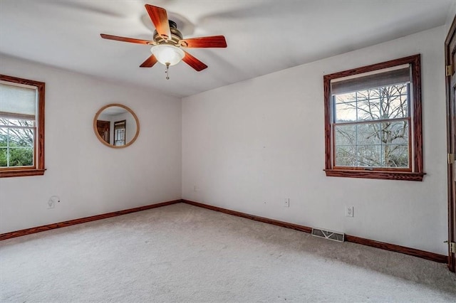 carpeted spare room featuring ceiling fan