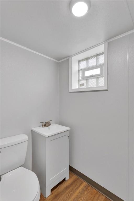 bathroom featuring sink, hardwood / wood-style floors, ornamental molding, and toilet