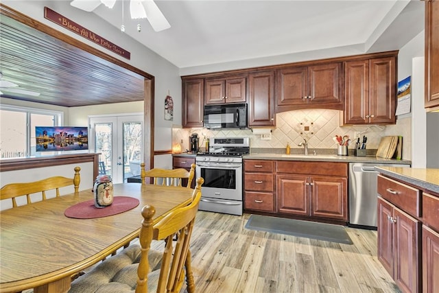 kitchen featuring french doors, tasteful backsplash, stainless steel appliances, sink, and light hardwood / wood-style floors