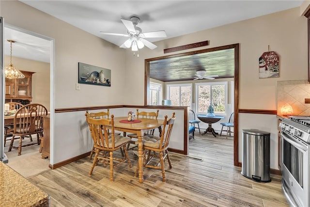 dining room featuring light hardwood / wood-style floors and ceiling fan with notable chandelier