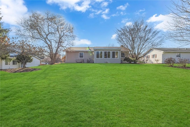 rear view of house featuring a yard