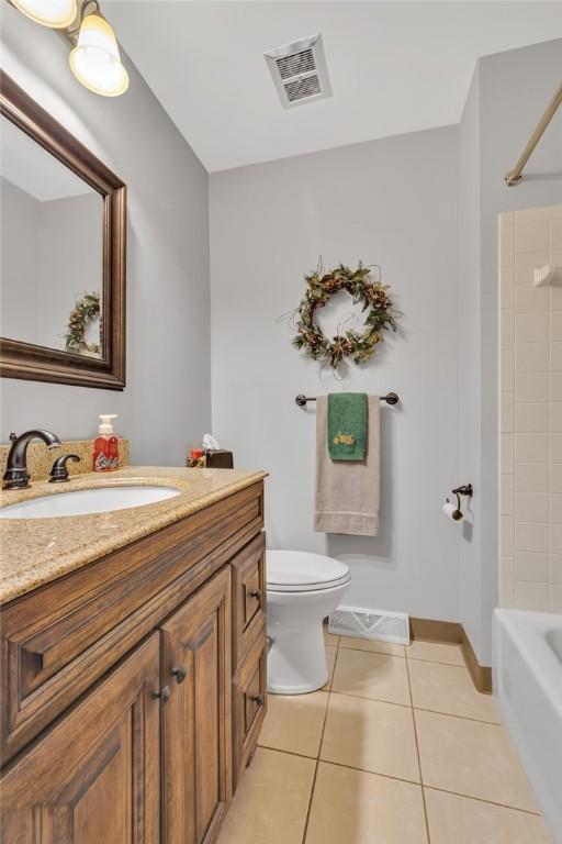 full bathroom with tile patterned flooring, vanity,  shower combination, and toilet