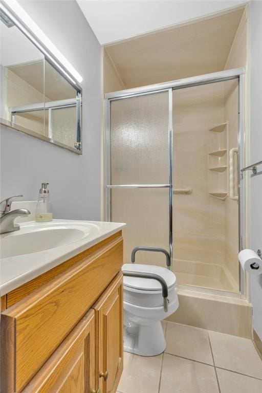 bathroom with toilet, vanity, tile patterned floors, and a shower with shower door