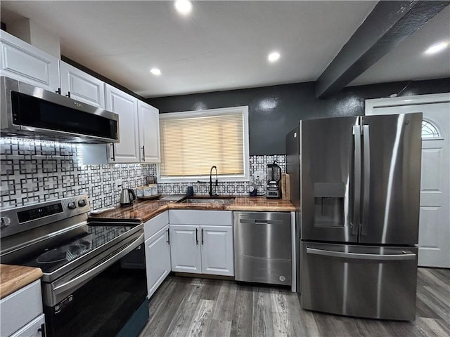 kitchen featuring dark hardwood / wood-style flooring, white cabinetry, sink, and appliances with stainless steel finishes