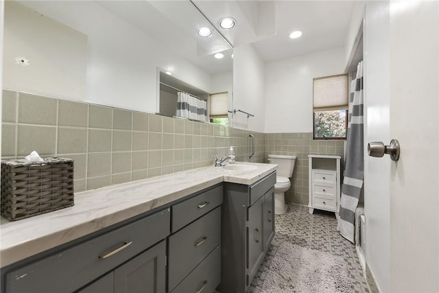 full bathroom with toilet, tile patterned floors, vanity, tile walls, and recessed lighting