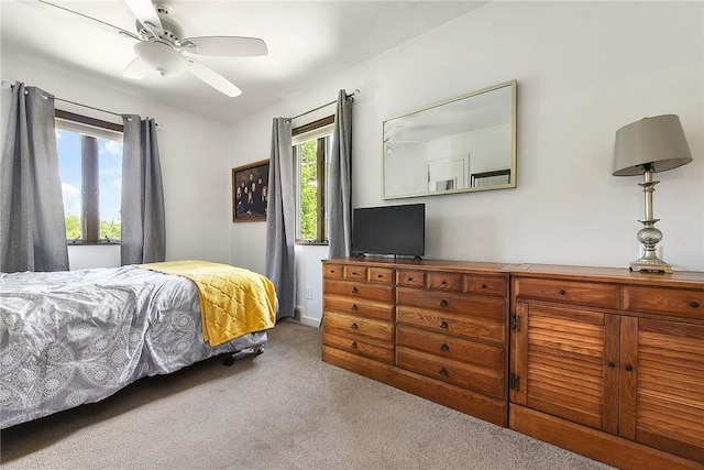 bedroom with a ceiling fan and light colored carpet