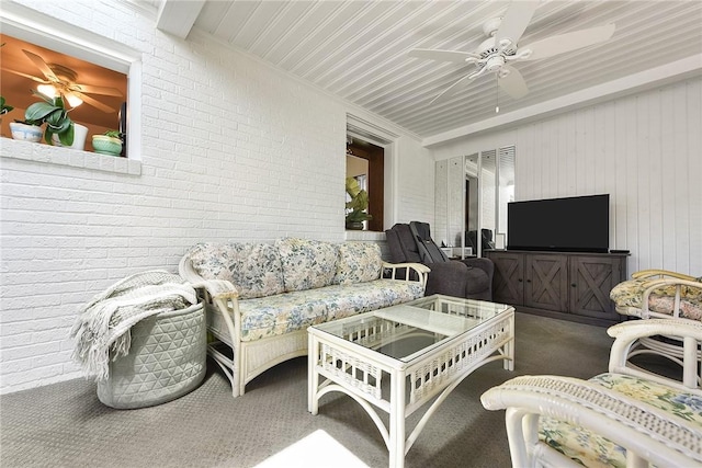 interior space featuring brick wall, carpet floors, and a ceiling fan