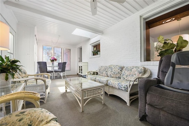 living area with brick wall, carpet, a skylight, and a ceiling fan