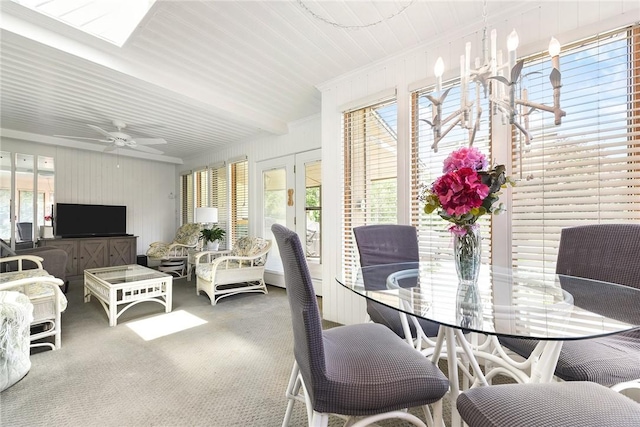 sunroom featuring ceiling fan with notable chandelier