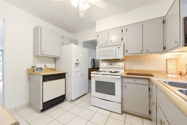 kitchen with white appliances, light tile patterned floors, light countertops, and backsplash