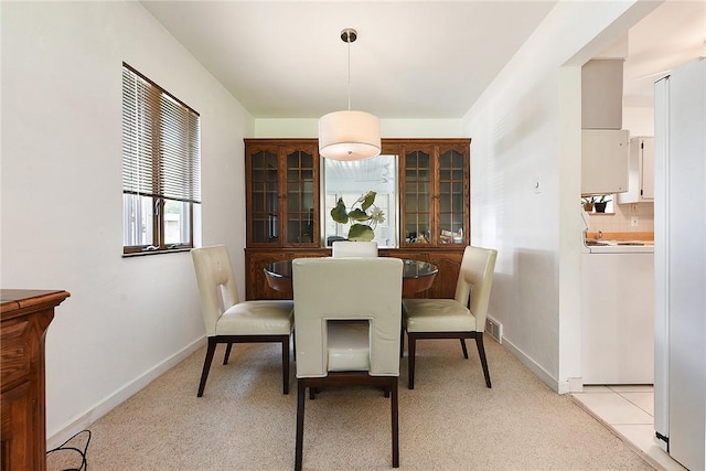 dining room featuring stacked washer and dryer, baseboards, and visible vents