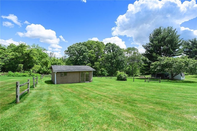 view of yard featuring a storage unit, an outdoor structure, and fence