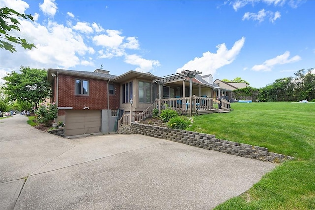 view of front facade with an attached garage, a front yard, concrete driveway, and brick siding