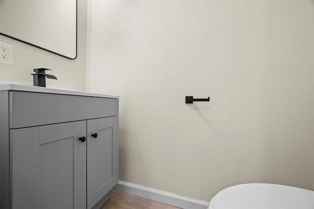 bathroom with hardwood / wood-style flooring, vanity, and toilet