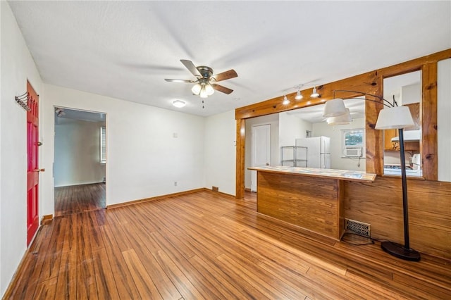 interior space featuring wood-type flooring, track lighting, and ceiling fan