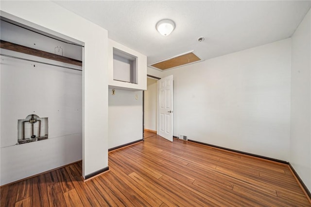 unfurnished bedroom featuring hardwood / wood-style flooring and a closet