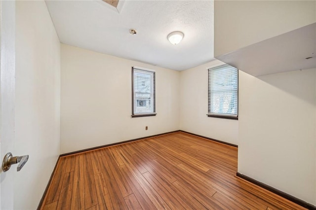 bonus room featuring a wealth of natural light, light hardwood / wood-style flooring, and a textured ceiling