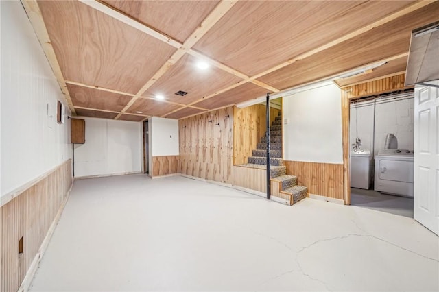 basement with wood walls and washer and dryer